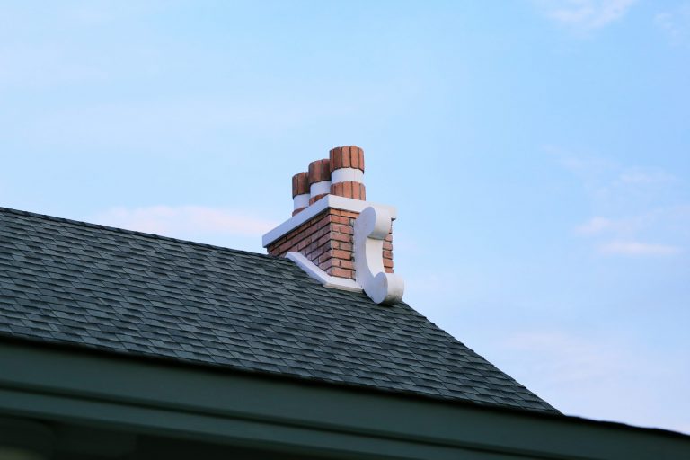 chimney-on-house-roof-closeup-blue-sky-background